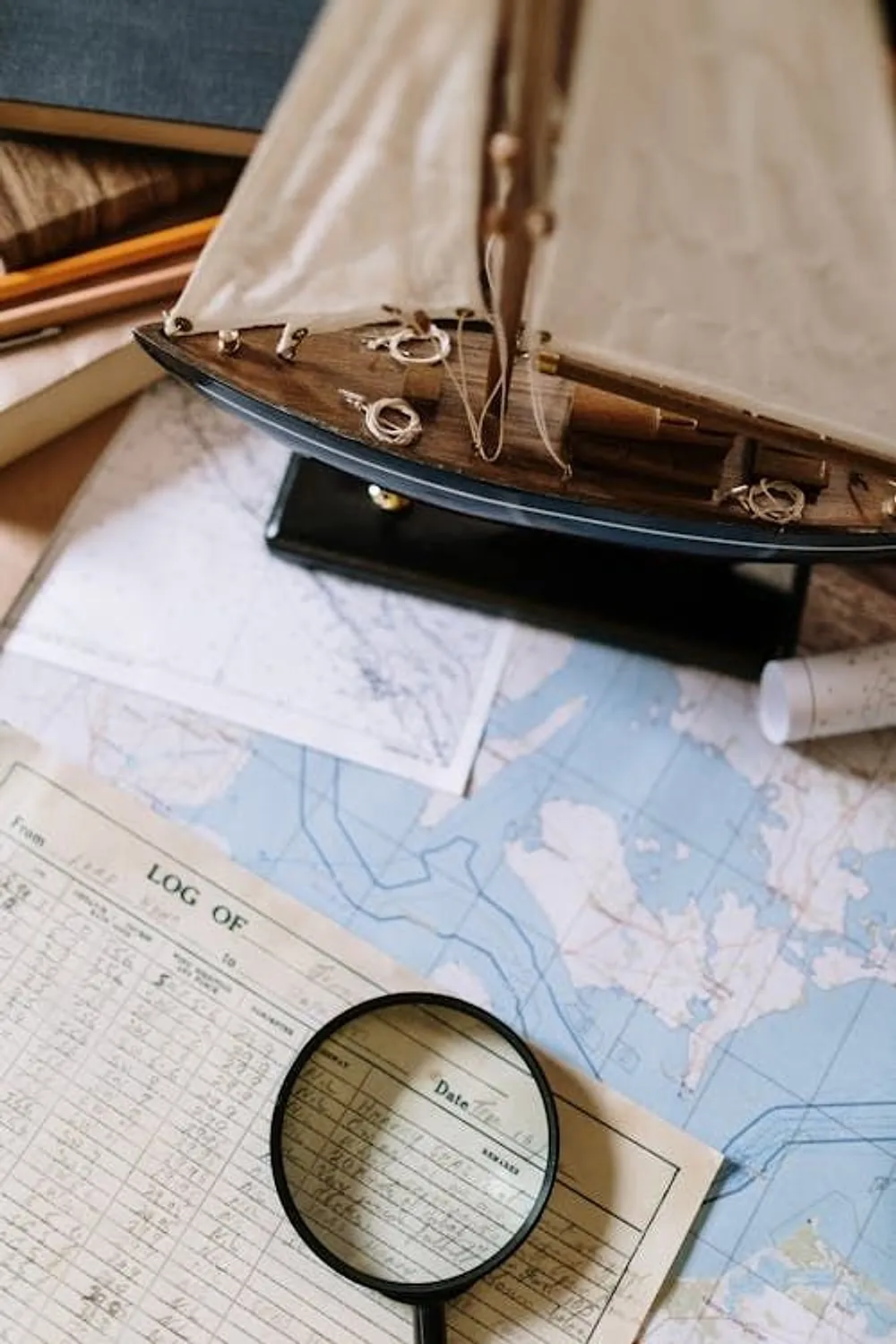 Nautical charts, a ship's log, and a model vessel, the tools of careful chartering